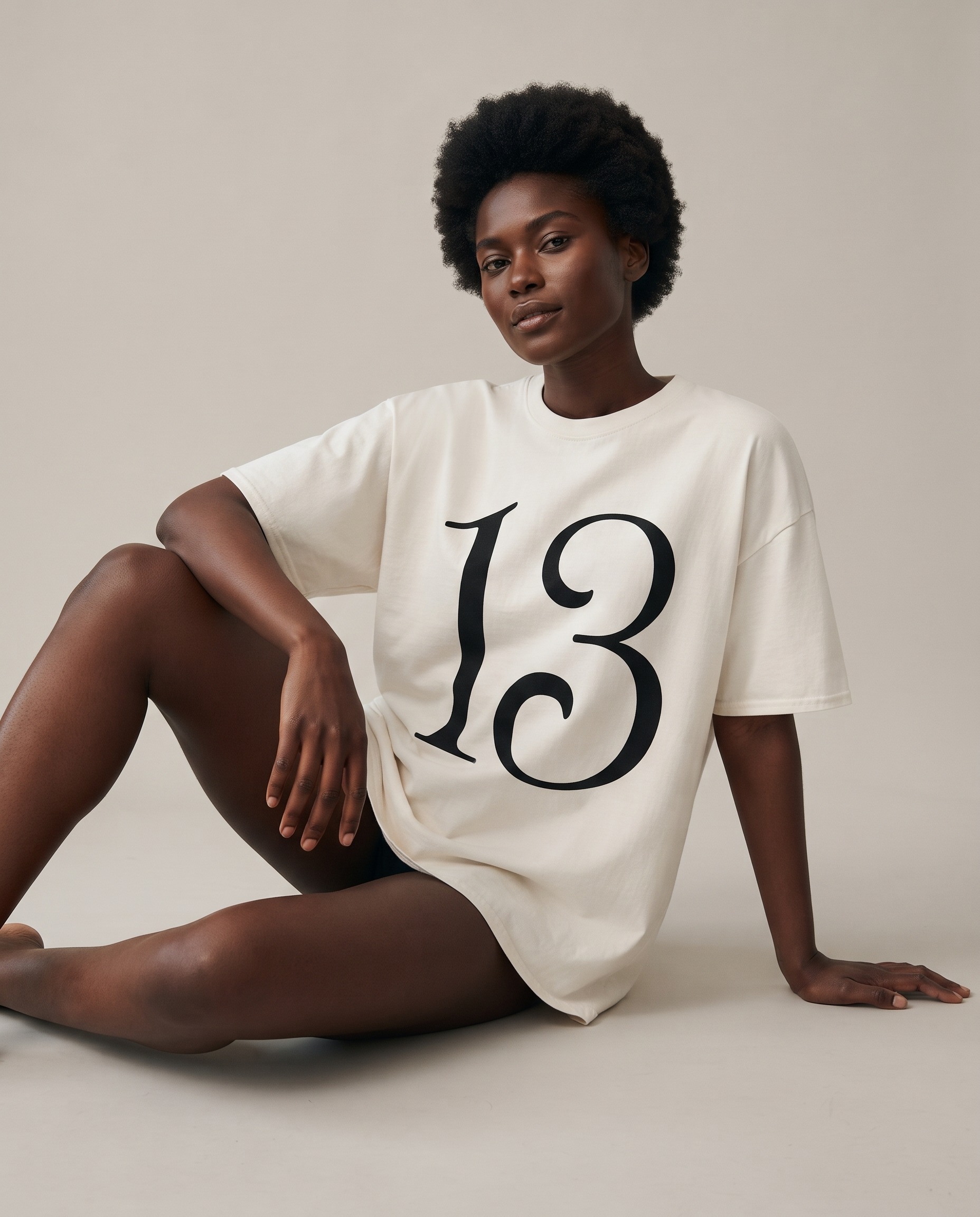 13 T-Shirt by SUPERWAPA, white oversized tee worn by a model
